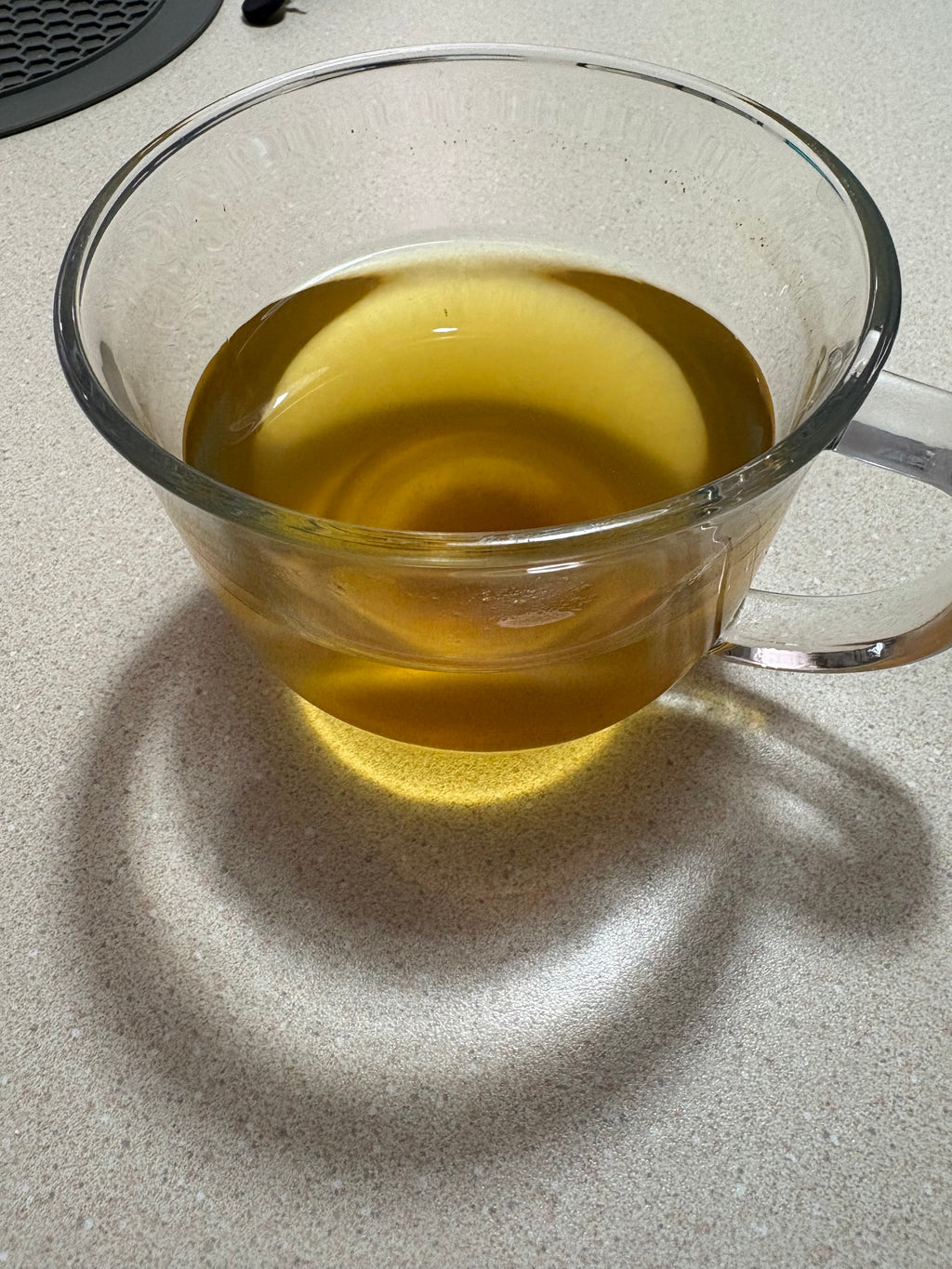 Brewed golden turmeric tea from Mehra Cup served in a clear glass cup