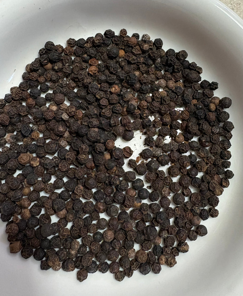 Whole black peppercorns used in Mehra Cup turmeric tea blend